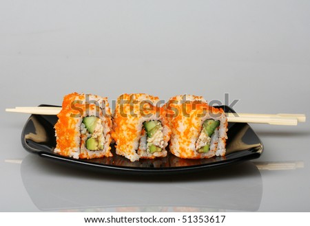 japanese  rolls on black plate. good food.