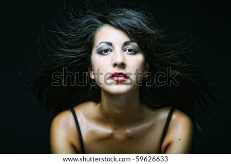 Fashion girl posing on dark background - portrait