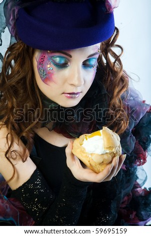 young woman with creative make-up in doll style with cake.