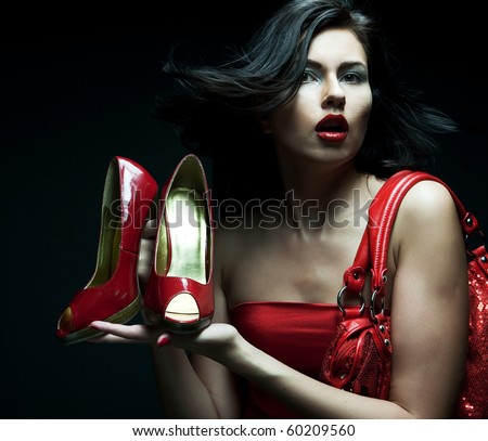 fashion model with red bag and red shoes. on black background.