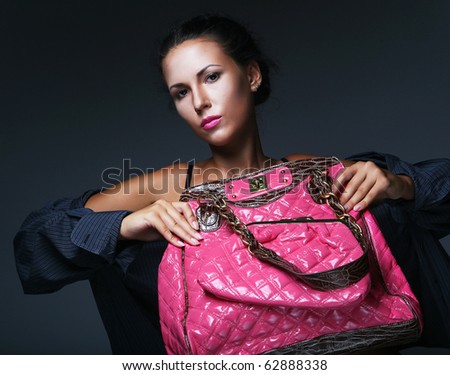 Fashion model with bag. posing in the studio