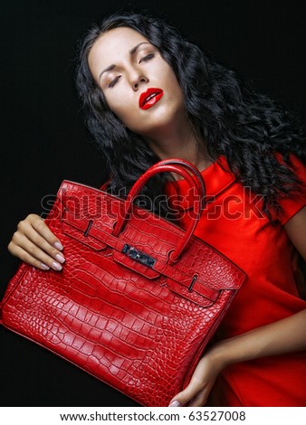 Fashion model with bag. posing in the studio