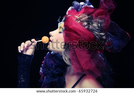 Girl with  with creative make-up holds  lollipop. Doll style.