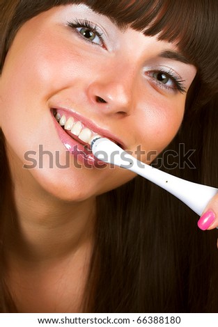 Young beautiful smiling woman with great white teeth holding a toothbrush