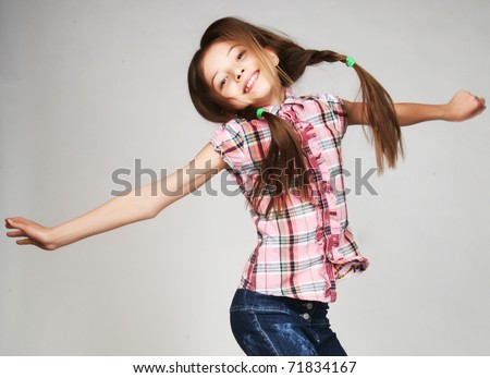 little girl jumps on a gray  background