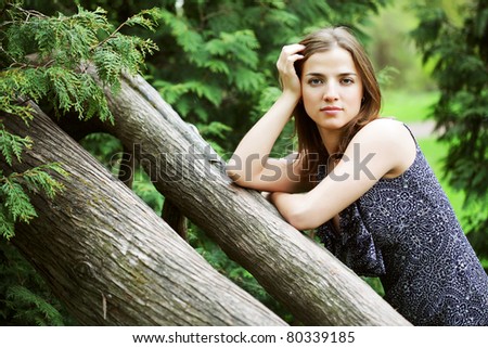 Portrait of a beautiful young  woman on a tree