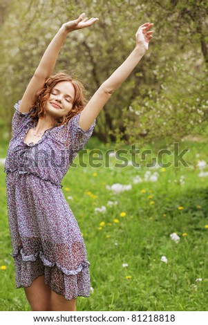 Beautiful young woman in romantic dress relaxing in garden