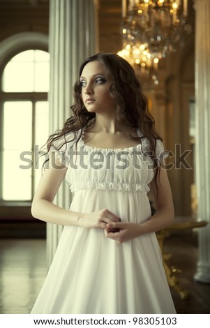 Portrait of a beautiful young victorian lady in white dress.Russian palace.
