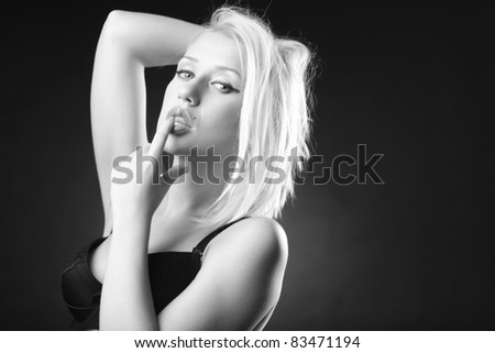 Black and white picture of a beautiful blonde model in a black bra in a sensual pose.