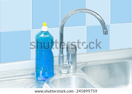 blue dish washer on kitchen with cleaner, tap, tile water drops