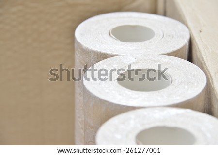 beige wallpaper rolls in cardboard box
