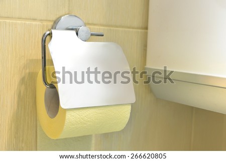 Toilet yellow paper and toilet paper holder.