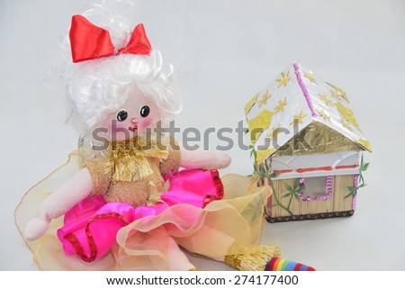 girl\'s doll with small house over white