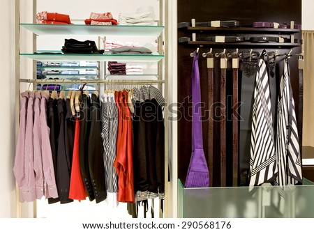 inside fashion store (Men\'s and women\'s shirts, blouses and accessories on hangers )