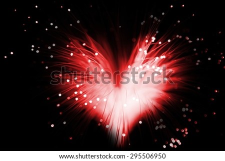 red colored abstract heart made from fibers  lights  in darkness ( love concept )