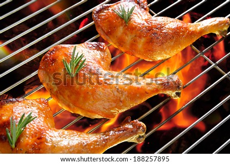 Grilled chicken thigh on the flaming grill.