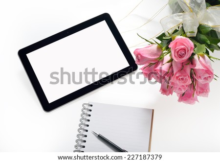 Tablet computer and beautiful bouquet of flowers isolated on white