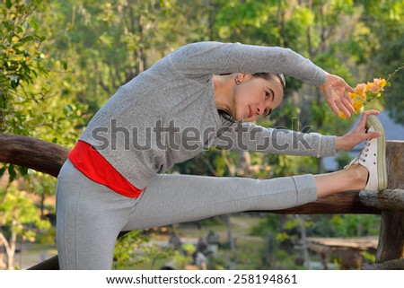 Middle aged woman stretching in the park