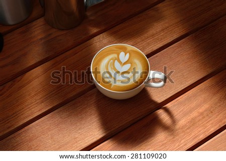 Cup of cafe latte art on wooden table, tulip shape
