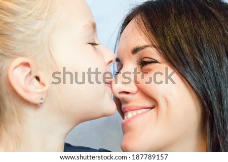 Photo of kissing happiest mother and daughter