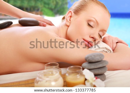 Stone therapy. Woman getting a hot stone massage