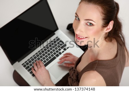 Businesswoman with laptop sitting on the floor isolated on white background