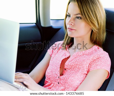 business travel: busy businesswoman with laptop in car
