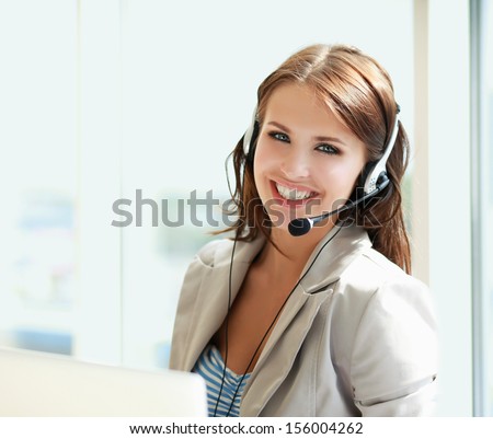 businesswoman talking on the phone while working on her computer at the office businesswoman talking on the phone while working on her computer at the office