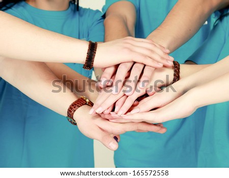friends putting their hands together in a sign of unity and teamwork