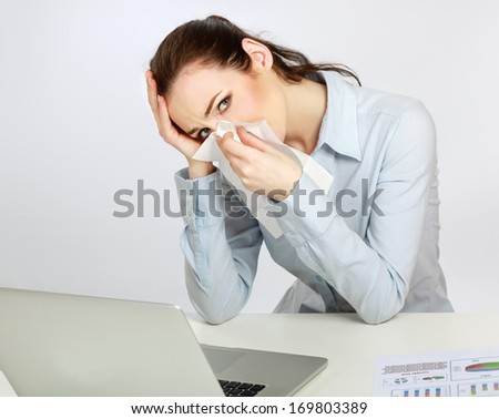 Young woman sneezing, isolated on white background