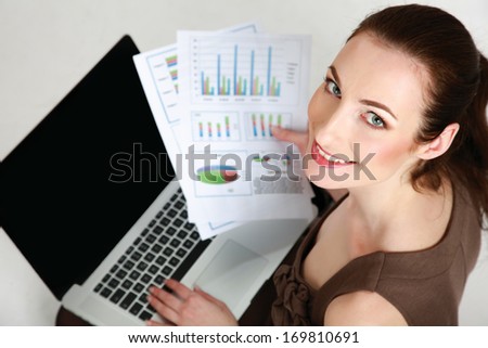 Businesswoman with laptop sitting on the floor isolated on white background