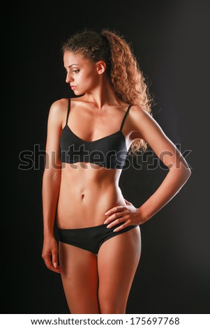 Portrait of young beautiful fitness woman, isolated on black background