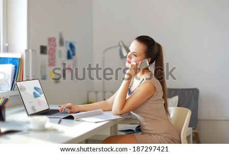 Happy office girl at desk working on laptop