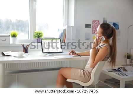 Happy office girl at desk working on laptop