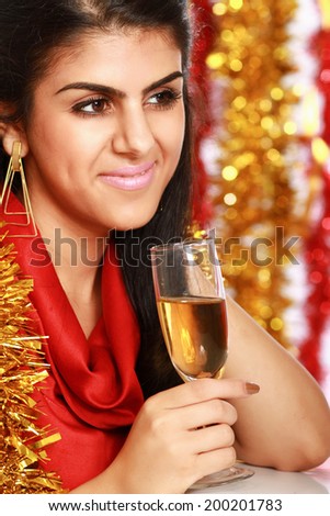 Beautiful young brunette woman drinking champagne at christmas party.
