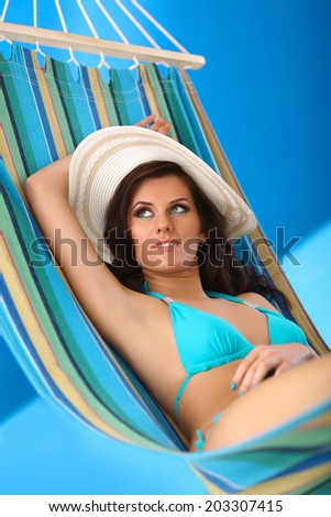 Woman relaxing on hammock with white hat