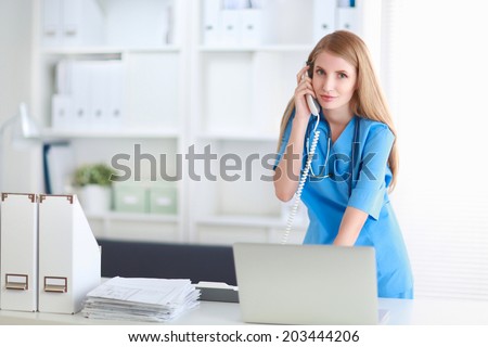 Medical doctor woman with computer and telephone.