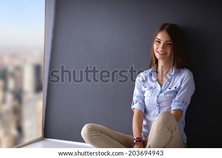 Young woman sitting on the floor near dark wall
