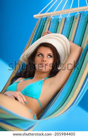 Woman relaxing on hammock with white hat