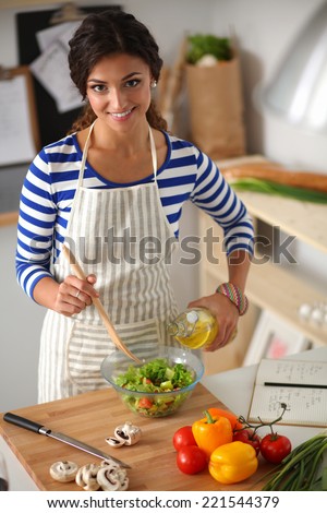 Smiling young woman  mixing fresh salad