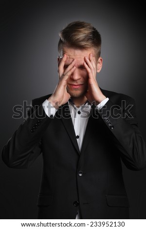 Executive man having head ache isolated on gray  background