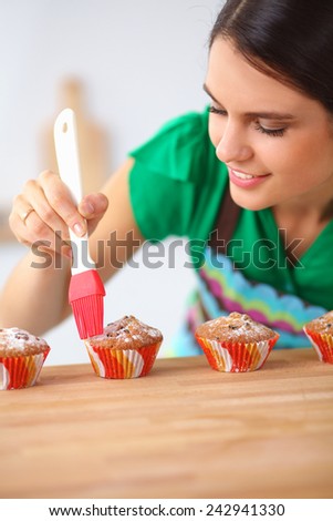 Young woman is making cakes in the kitchen