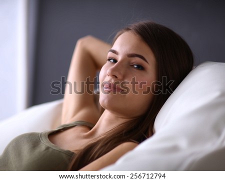 Closeup of a smiling young woman lying on couch
