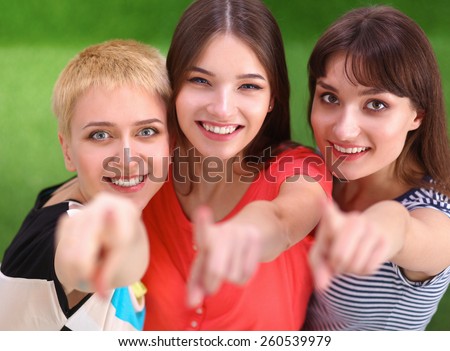Three happy girls pointing fingers at you choosing