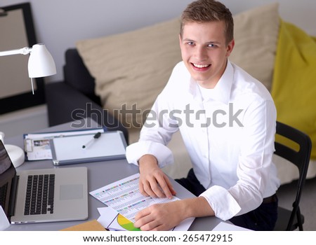Young businessman working in office, standing near desk