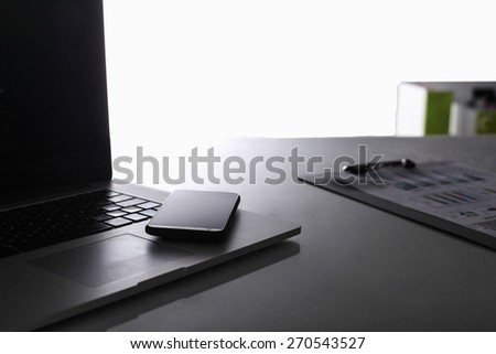 Modern home office with computer and laptop, folder, phone lying on the desk