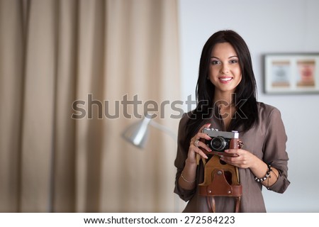 Woman sitting on a sofa in her house with camera