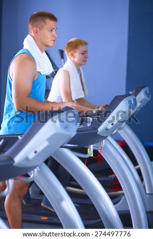 Man running on a treadmill in a fitness club
