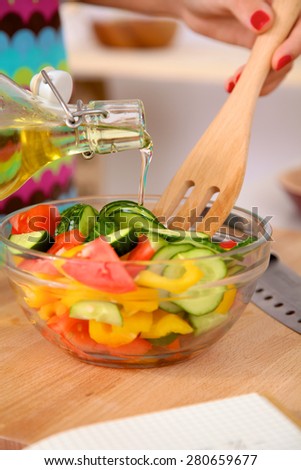 Young woman mixing fresh salad