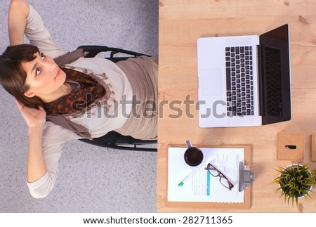 Business woman relaxing with  hands behind her head and sitting on a chair